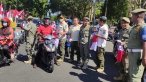 Sambut HUT RI ke 77, Satpol PP Bondowoso Ikut Bagikan Bendera Merah Putih