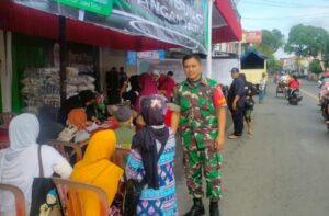 Babinsa Ingatkan Warga Selalu Patuhi Prokes Covid-19 Saat Operasi Pasar Berlangsung